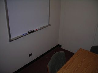 image of study room showing small table, 3 chairs white board on wall.