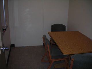 image of study room showing small table, 3 chairs white board on wall.