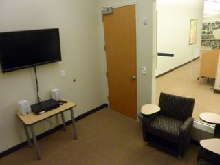 image of study room showing small table, PC/DVD player, wall mounted TV and 4 desk-chairs