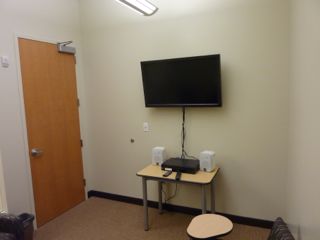 image of study room showing small table, PC/DVD player, wall mounted TV and 2 desk-chairs